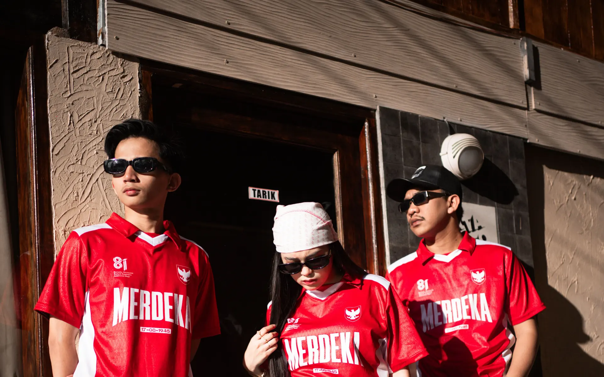 Tiga anggota tim memakai jersey Merdeka custom MAKNA